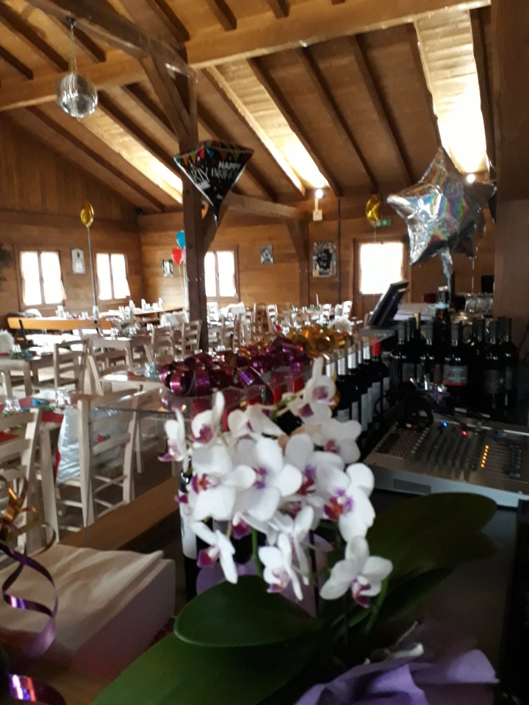 Für eine Feier dekorierter Gastraum mit Blumen und Ballons